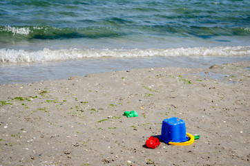 Fototapeta na wymiar Close-up view of different kids toys on sand beach .