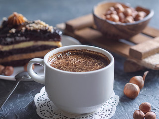 Breakfast. Coffee morning , with a slice of cake and hazelnuts on a textural background.