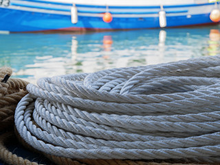 Close up of a nautical rope with the and a fishing ship in the background
