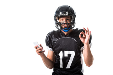 American Football player with smartphone and okay sign Isolated On White © LIGHTFIELD STUDIOS