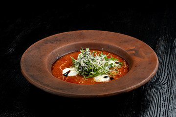 Tomato soup with arugula and grated cheese.