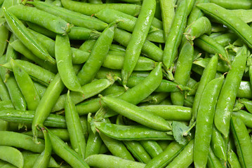 Fresh pea pods as background. Top view.