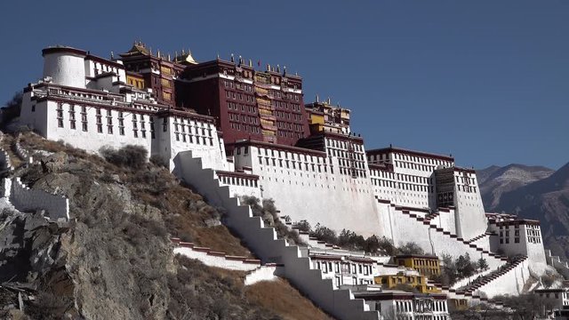 Facade of mighty Potala palace set in the mountains of Lhasa on the high altitude Tibetan plateau, stunning architecture and historic building 