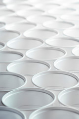 Fototapeta premium Background texture of white plastic cups standing in a row. Zero waste concept, plastic free