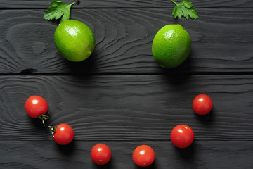 Emoticon of red cherry tomatoes, parsley leaves and limes