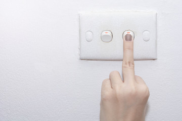 A middle finger turning on lighting switch on rough on white wall, Empty space for text your, Electric control concept, Earth hour concept, Copy space