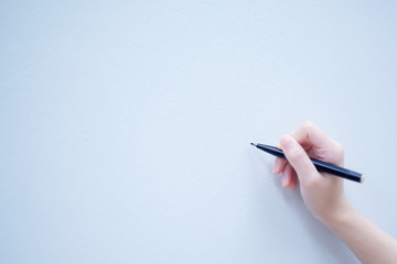 Black pen and human hand on copy space whiteboard