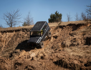 4x4 suv truck driving downhill on edge of hill. Off road concept