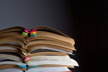 stack of opened books on a dark background, copy space