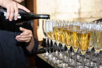 Bartender hand pouring champagne by the glass in restaurant, nightclub or bar. - 281289973