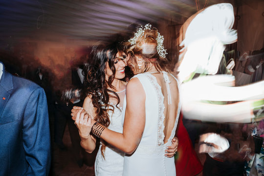 Portrait of a proud couple dancing each other with white wedding dresses