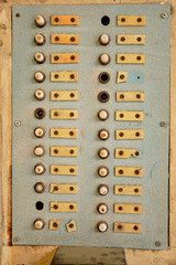 Vintage building call button panel, with broken buttons and nameless name plates
