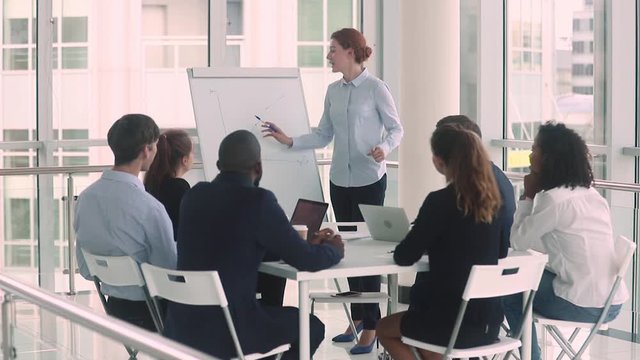 Female business trainer teaching multi-ethnic company staff during seminar