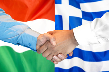 Business handshake on the background of two flags. Men handshake on the background of the Hungary and Greece flag. Support concept