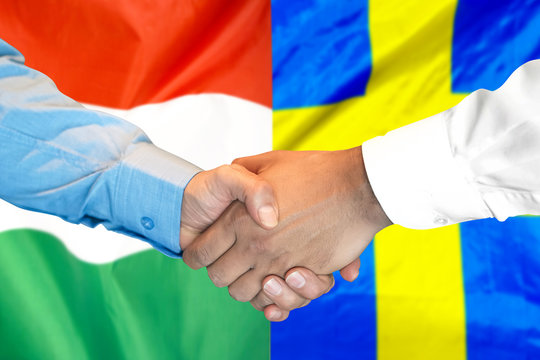 Business handshake on the background of two flags. Men handshake on the background of the Hungary and Sweden flag. Support concept