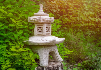 Decorative plaster figure on a birch stump in a green garden in summer. Copy space