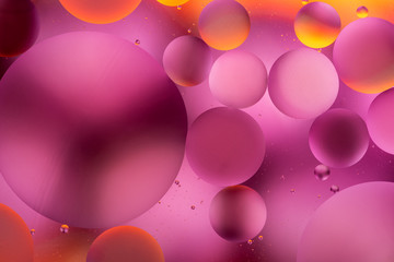 bright oily drops in water with colorful background, close-up 