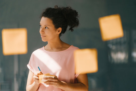Woman brainstorming in office using adhesive notes