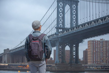 man walks on the background of the brooklyn bridge
