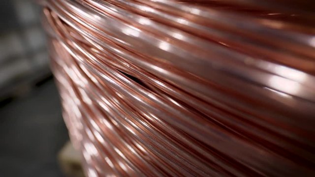 Copper rod. Thick copper wire coiled into a huge bobbin. Copper is one of the rare metals used everywhere.