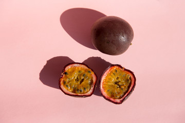 Fresh passion fruit isolated on a pastel pink background in top view. Ripe tropical passion fruit...