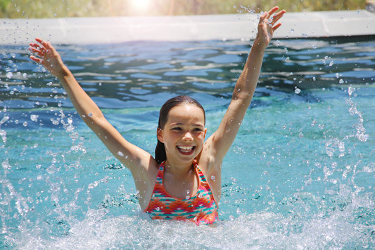 Ein M&auml;dchen planscht in einem Swimmingpool