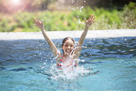 Ein M&auml;dchen planscht in einem Swimmingpool