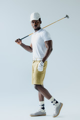 confident african american golf player looking at camera on grey background