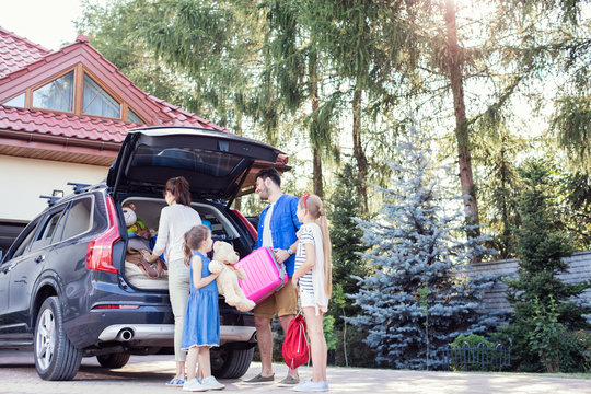Happy family packing car for vacation