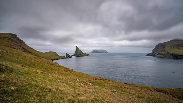 Wde angle view timelapse of Drangarnir gate in front of Tindholmur with Mykines in the background
