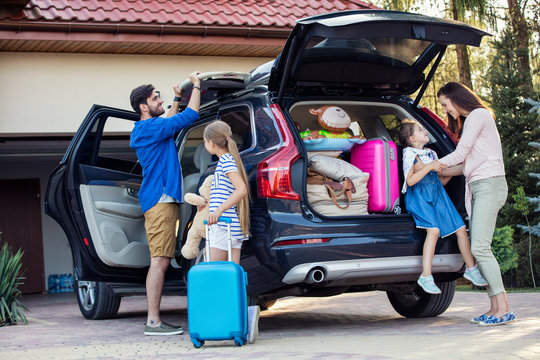 Happy family packing car for vacation