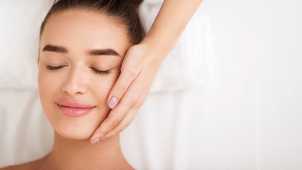 Naklejka premium Woman getting facial spa treatment, enjoying face massage