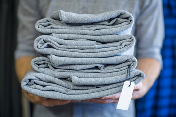 Man holding stack of folded clothes