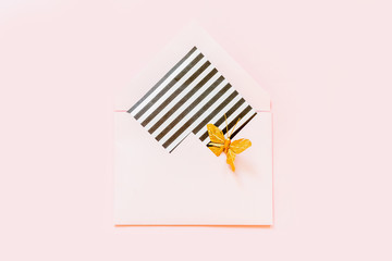 Top view of a decorative envelope. Flat layout, copy space. Concept of christmas, new year, birthday party. Blank mockup card in kraft envelope. Various striped and dotted designs. pink background.