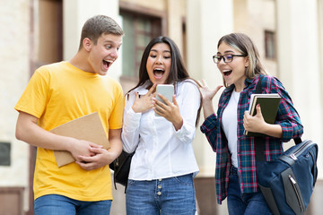 Surprised students checking exam results on smartphone