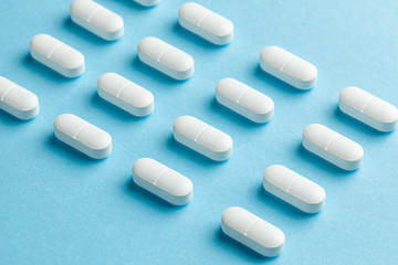 White pills on blue background.