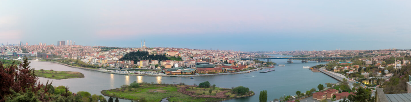 Istanbul city view from Pierre Loti Teleferik station overlooking Golden Horn with Halic Bridge, Golden Horn Metro Bridge and historical mosques at dusk time, Eyup District, Istanbul, Turkey