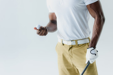 cropped view of african american golf player holding ball isolated on grey