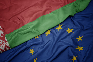 waving colorful flag of european union and flag of belarus.