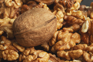 walnuts scattered on a black paper background