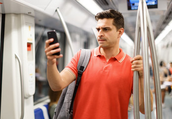 Man is looking on phone in the train