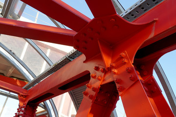 Red iron beams bolted on. Angular connection of several iron beams in one place.