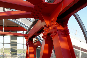 Red iron beams bolted on. Angular connection of several iron beams in one place close up.