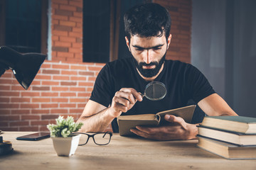 man hand magnifier with  book in office