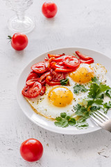 Breakfast fried eggs with tomatoes
