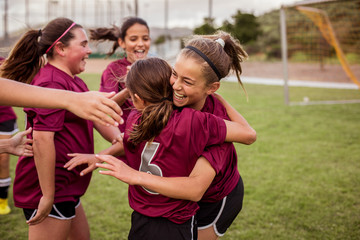Players celebrating success after soccer match in field