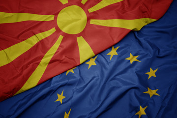 waving colorful flag of european union and national flag of macedonia.