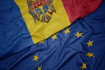 waving colorful flag of european union and national flag of moldova.