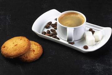 white cup of fresh hot coffee, grains of coffee and sugar cubes