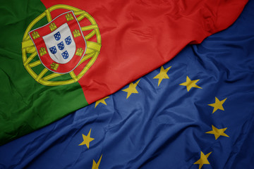 waving colorful flag of european union and national flag of portugal.